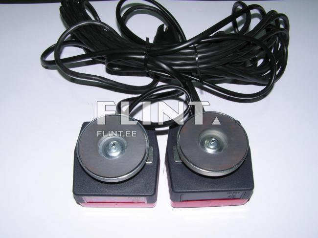 Kaks musta nurgalist seadet, mille ülaosades on metallist kettad. Seadmete allosas on punane osa. Kummalgi seadmel on pikk must kaabel, mis on kokku keeratud.