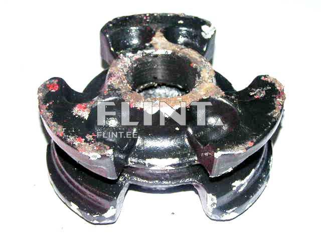 Ümar must plastikdetail, millel on keskel avaus ja neli laiemat sirget serva. Detail on kulunud, pinnal on nähtavad kriimustused ja rooste.