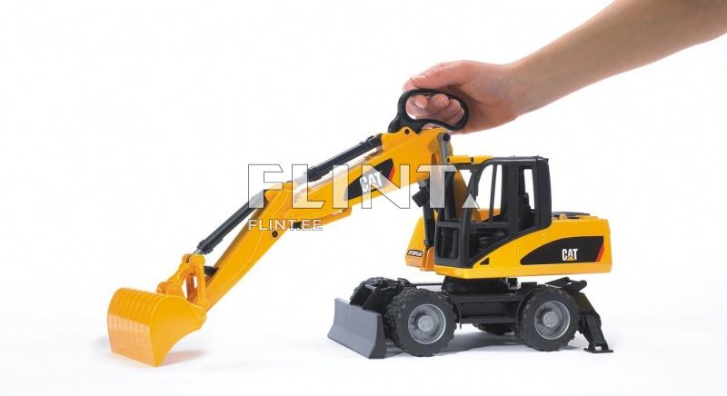 Käsi hoiab CAT kaevurit, millel on kollane ja must värv. Kaevuri kaevandamisots on alla suunatud ja detailne.