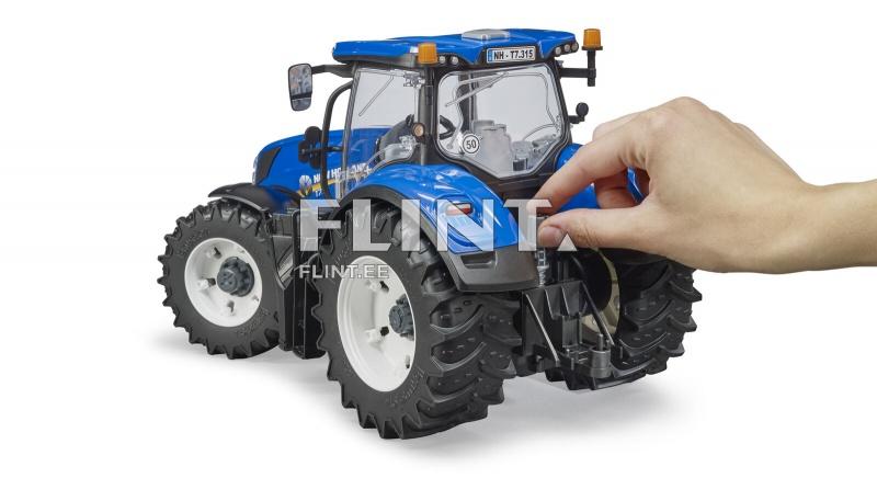 Sinine traktor, millel on suured mustad rehvid ja valged veljed. Traktoril on erinevaid detaile, sealhulgas peegel ja vilkuv tuli. Käsi puudutab traktori tagumist külge.