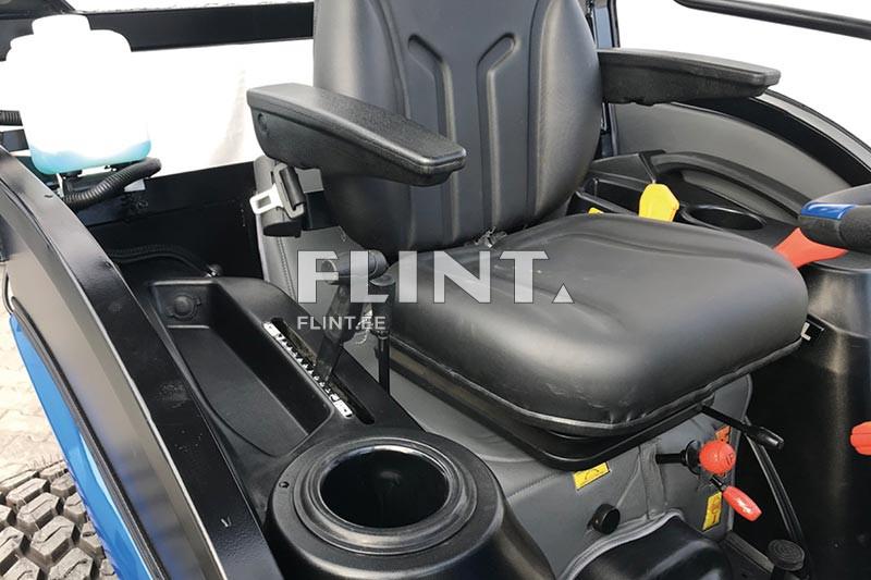 Musta nahkist iste, millel on kaks käsitoega, asub traktori kabiinis. Istme kõrval on erinevad juhtelemendid ja prügikast.