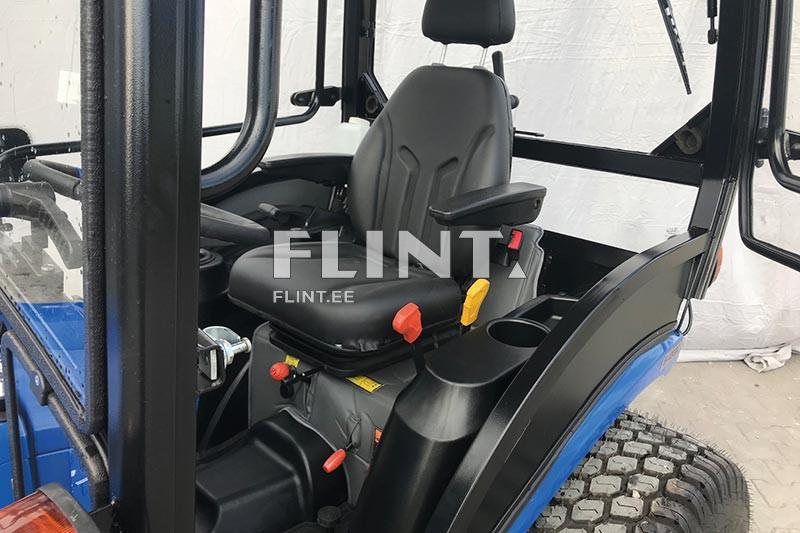 Pildil on traktori kabiin, milles on musta nahkistmega juhtimisistm. Istme kõrval on mitmed käigukangid ja reguleerimise nupud.