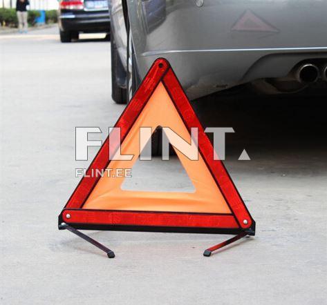 Kollane ja punane kolmnurkne ohumärk on maapinnal, sõiduki lähedal. Märgise keskel on tühi ruut.